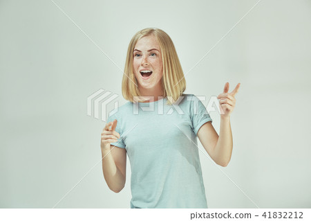 The happy freckled woman standing and smiling against gray background. The happy freckled woman standing and smiling against gray background. 41832212