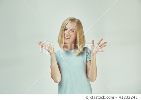 The happy freckled woman standing and smiling against gray background. The happy freckled woman standing and smiling against gray background. 41832243