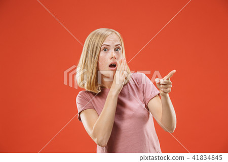 The young woman whispering a secret behind her hand over red background The young woman whispering a secret behind her hand over red background 41834845