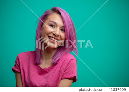 Young female model with pink hair, smiling broadly, feeling joy. 41837009