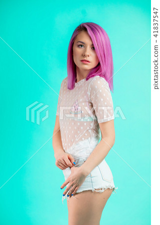 Fit woman with violet hair, dressed in transparent blouse and shorts isolated 41837547