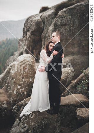 Wedding couple in love kissing and hugging near rocks on beautiful landscape 41838508