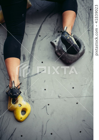 Bottom close up view of rock climber female feet on artificial climbing wall. 41839023