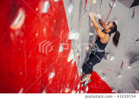 Young woman doing professional bouldering in climbing gym indoors Young woman doing professional bouldering in climbing gym indoors 41839154