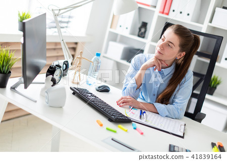 Young girl in the office sits at the computer desk. 41839164
