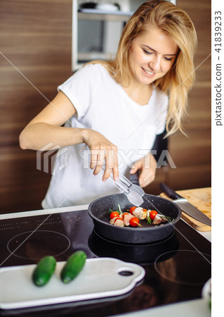 Closeup of woman roasting kebabs on frying pan Closeup of woman roasting kebabs on frying pan 41839233