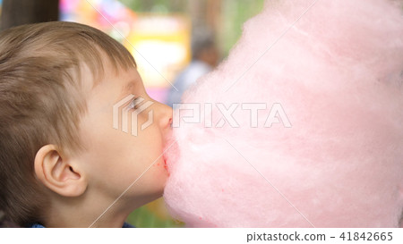Baby eating cotton candy in the Park. Sweet and airy dessert Baby eating cotton candy in the Park. Sweet and airy dessert 41842665