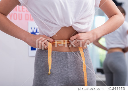 Smooth female hands falsifying waist measurement Smooth female hands falsifying waist measurement 41843653