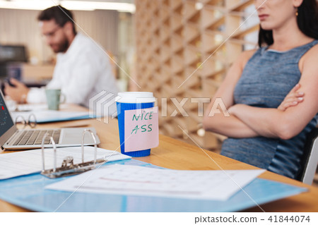 Insulted woman and a cup with a sticker Insulted woman and a cup with a sticker 41844074
