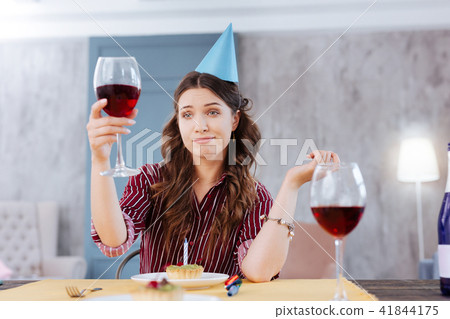 Woman making funny face while attending birthday party 41844175