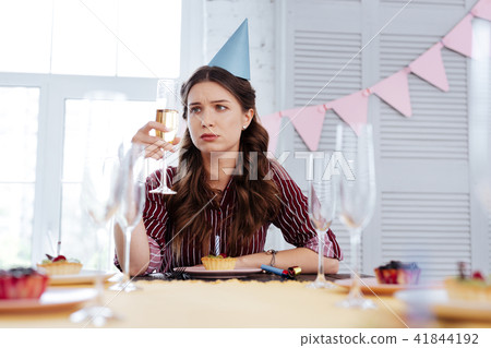 Woman feeling pessimistic at birthday party 41844192