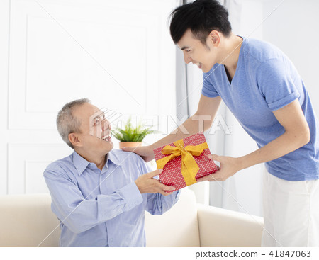 family celebrating and son giving gift to father 41847063
