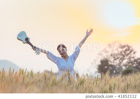 Beautiful asian woman playing ukulele Beautiful asian woman playing ukulele 41852112