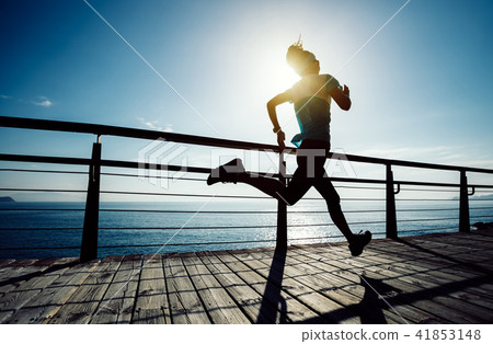 runner running on seaside boardwalk during sunrise runner running on seaside boardwalk during sunrise 41853148