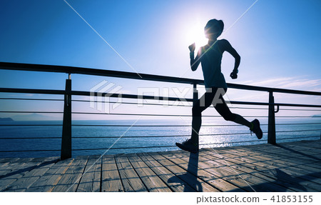runner running on seaside boardwalk during sunrise 41853155