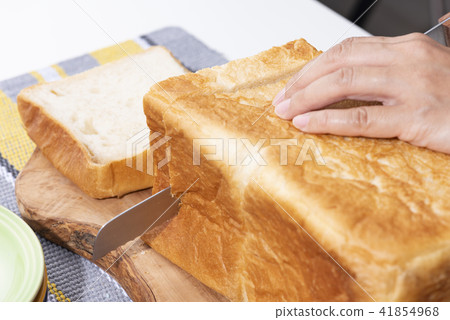Hand cutting bread 41854968