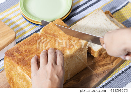 Hand cutting bread 41854973