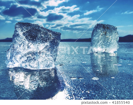 Ice on frozen surface with reflection, blue sky 41855540