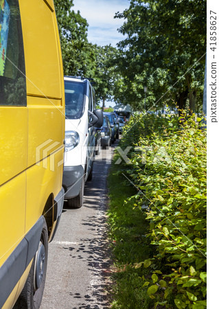 Row of cars parking on the street next to hedge Row of cars parking on the street next to hedge 41858627