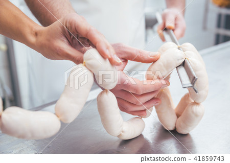 Butcher in butchery filling sausages Butcher in butchery filling sausages 41859743