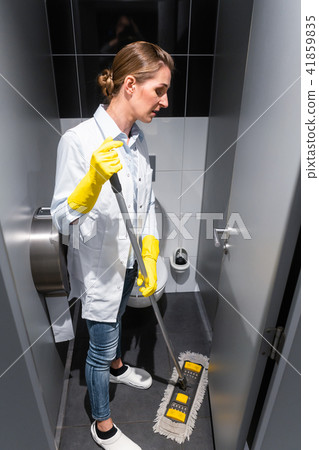 Cleaning lady or janitor mopping the floor in restroom 41859835