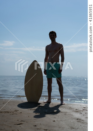 silhouette of a young man with a skimboard  41865951