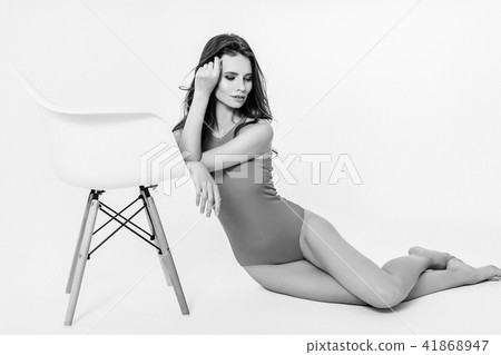 Woman in swimsuit leaning on chair 41868947