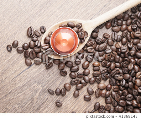 Wooden spoon and coffee capsule close up 41869145
