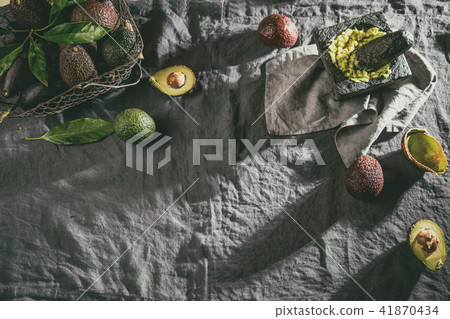 Avocado. Guacamole. Mexican guacamole sauce in stone mortar, full basket with avocado, half of Avocado. Guacamole. Mexican guacamole sauce in stone mortar, full basket with avocado, half of 41870434