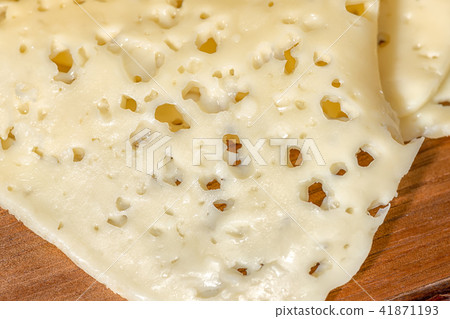 close up of holes cheese sliced on wooden texture close up of holes cheese sliced on wooden texture 41871193