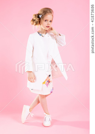 A teenage girl in light clothes posing on a pink background. A teenage girl in light clothes posing on a pink background. 41873686