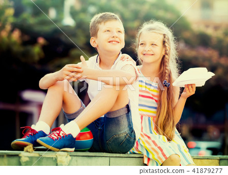 cheerful girl and boy sitting together in park cheerful girl and boy sitting together in park 41879277