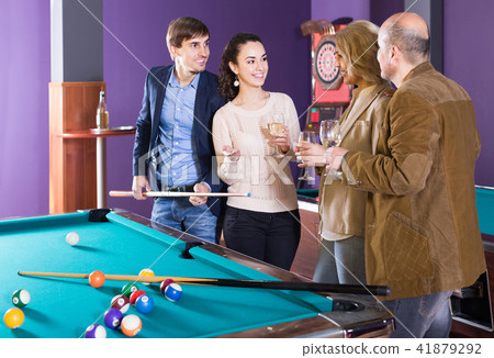 Mature and young couples hanging out in billiard club together Mature and young couples hanging out in billiard club together 41879292