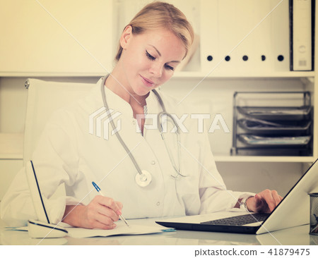 portrait of adult adult therapist writing and working with laptop in office workplace 41879475