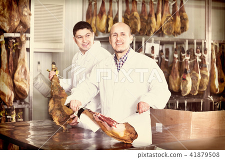 Portrait of sellers slicing tasty jamon for customers 41879508