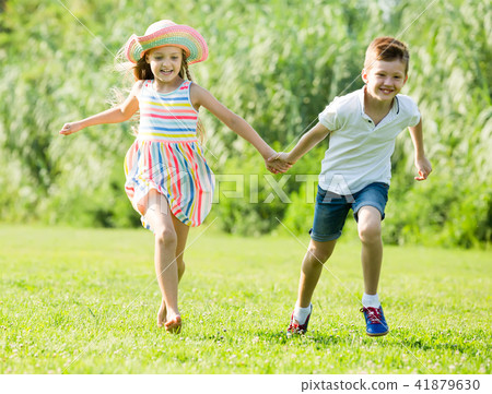 two smiling children active playing and running outdoors two smiling children active playing and running outdoors 41879630