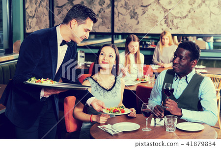 Waiter serving couple in restaurant 41879834