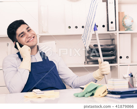 Man cleanaer is speaking on the phone instead of cleaning Man cleanaer is speaking on the phone instead of cleaning 41879866