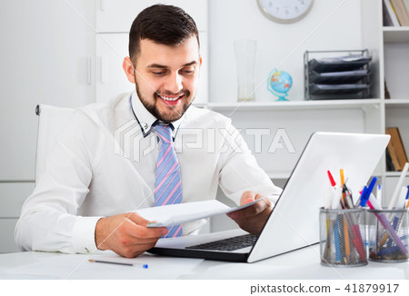 Young male worker working productively on project in office 41879917