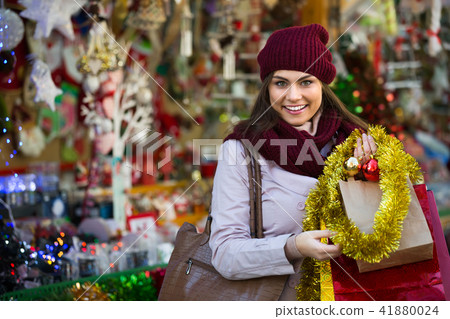 Girl choosing Christmas decoration at market. Girl choosing Christmas decoration at market. 41880024