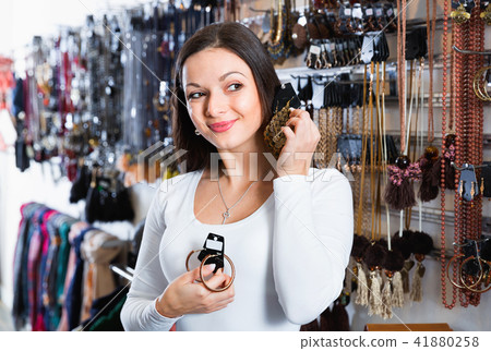 Smiling girl choosing fashionable earrings in the jewelry store 41880258