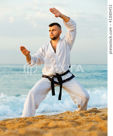 Guy doing karate poses at sunset sea shore Guy doing karate poses at sunset sea shore 41880452