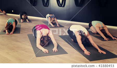 Women exercising yoga poses in fitness center Women exercising yoga poses in fitness center 41880453