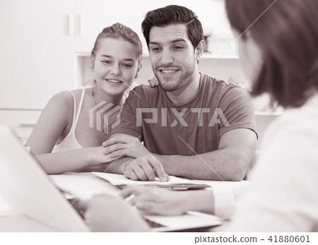 Loving couple with female designer at home 41880601