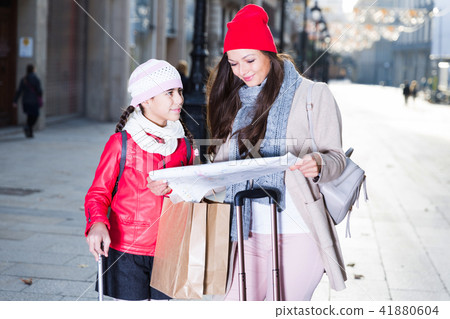 girl with mother holding map outdoors girl with mother holding map outdoors 41880604