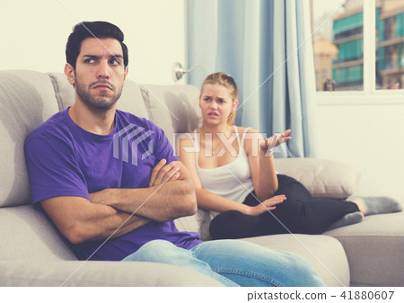 Frustrated guy on couch with dissatisfied girlfriend Frustrated guy on couch with dissatisfied girlfriend 41880607
