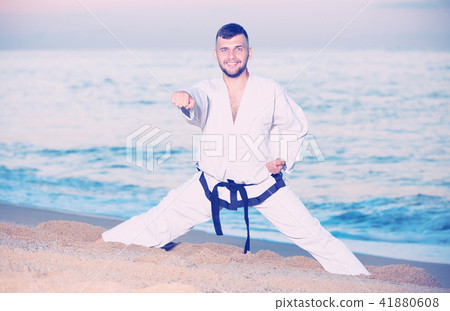 Laughing male doing karate at ocean quay Laughing male doing karate at ocean quay 41880608