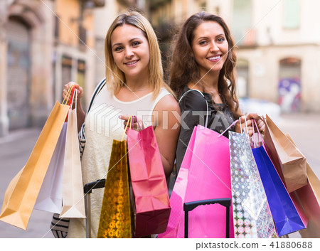 Two young women holding shopping bags. 41880688
