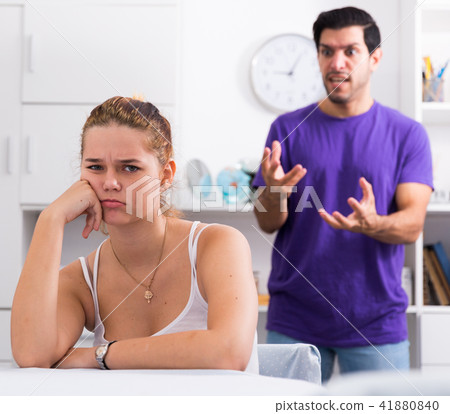 Frustrated girl at table with angry boyfriend Frustrated girl at table with angry boyfriend 41880840