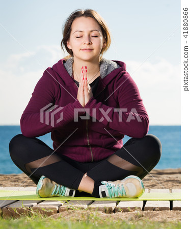 Positive young woman training yoga 41880866